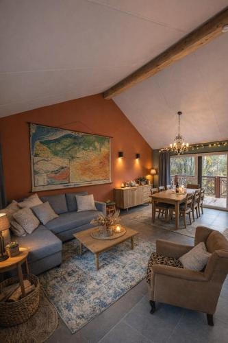 a living room with a couch and a table at Au Bois Chantant in Somme-Leuze
