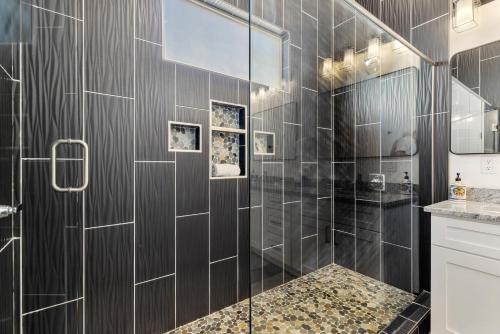 a bathroom with a shower with black tiles at Azure Abode at Sand Hollow Resort in Hurricane