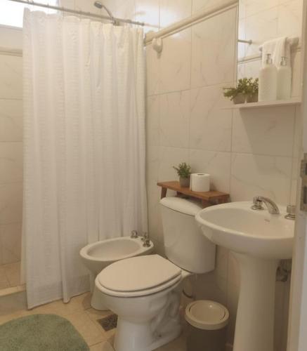 a white bathroom with a toilet and a sink at Departamentos A&B in Resistencia