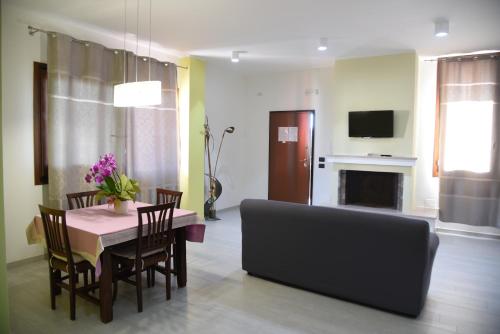- un salon avec une table, des chaises et un canapé dans l'établissement Green House, à Cavallino di Lecce