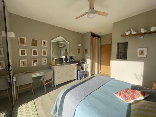 a bedroom with a bed and a desk with a computer at 1 Brin à part in Maubec