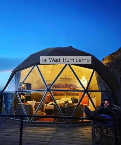 a man is sitting in a igloo tent at Taj Wadi Rum camp in Wadi Rum