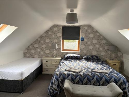 a bedroom with a bed and a chair in a attic at The Gatehouse in Upwell