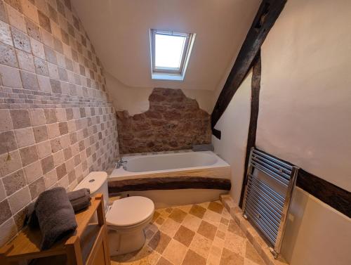 a bathroom with a toilet and a bath tub at The Farmhouse in Teignmouth