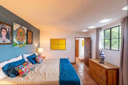 a bedroom with a large bed with blue sheets at Business in-suite with office in San Miguel de Allende