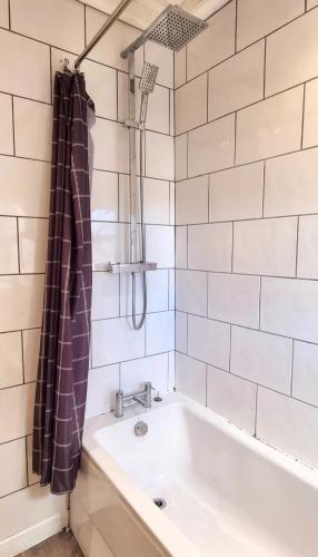 a bathroom with a tub and a sink at Sleepy Snug in Swansea