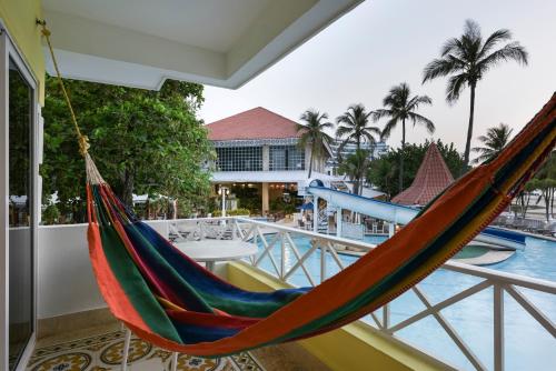 a hammock on a balcony next to a pool at Hotel Las Americas Casa de Playa in Cartagena de Indias