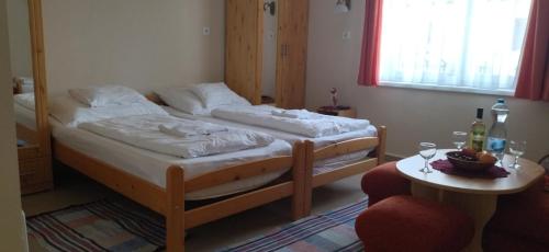 a bedroom with a bed and a table with two chairs at KOÓS VENDÉGHÁZ in Uppony