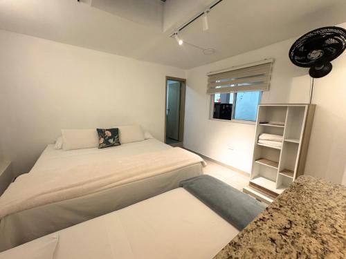 a small bedroom with a bed and a shelf at Casa Mompa in Bucaramanga