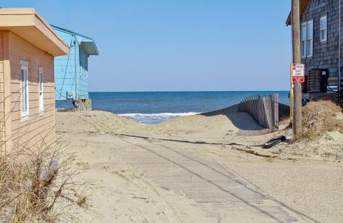 a sand pile next to a building and the ocean at Ocean Wynns - Nags Head MP 13, 20 Yards to the Beach, Ocean Views, Close to Attractions in Nags Head