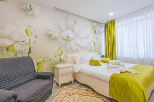 a bedroom with a bed and a chair and flowers on the wall at Damone Residence in Gura Humorului