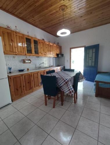 a kitchen with a table and chairs and a kitchen with a refrigerator at Sunny Home in Anaxos