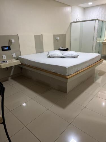 a large bed in a room with a mirror at Motel Canadá moto gp in Senador Canedo