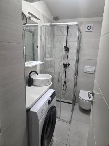 a bathroom with a shower and a washing machine at Apartment Central in Šibenik