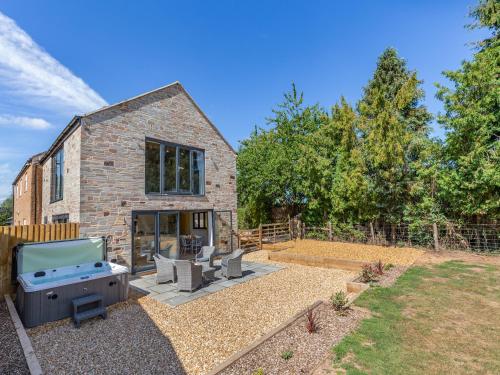a backyard with a barbecue and a house at Cathill Cottage in Creech Saint Michael