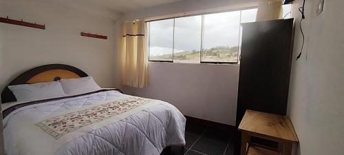 a bedroom with a bed and a window at Hospedaje Tikari in Chincheros