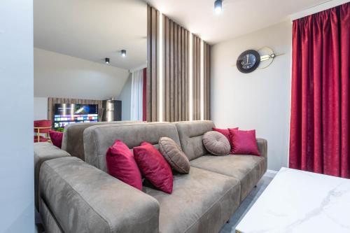 a living room with a couch with pink pillows at Golden peak Blidinje in Blidinje