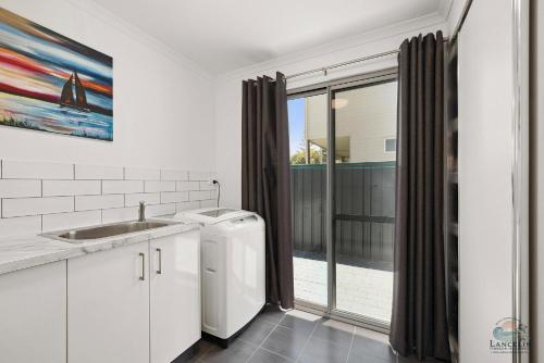 eine weiße Küche mit Spüle und Fenster in der Unterkunft Seagulls in Lancelin