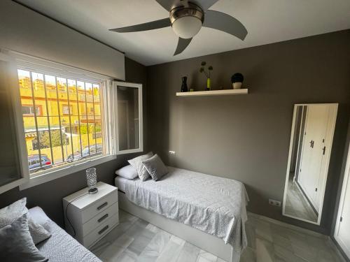 a bedroom with two beds and a ceiling fan at PuertoHouse in El Puerto de Santa María