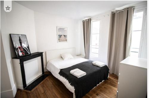 En eller flere senge i et værelse på Appartement eiffel tower