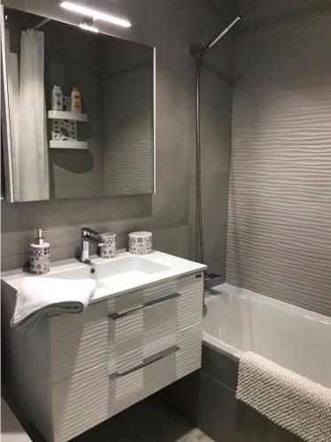 a bathroom with a sink and a bath tub at PuertoHouse in El Puerto de Santa María