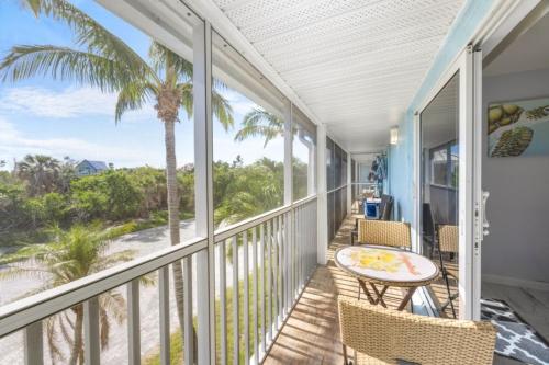 a balcony with a table and chairs and a palm tree at Seashells Unit 44 in Sanibel