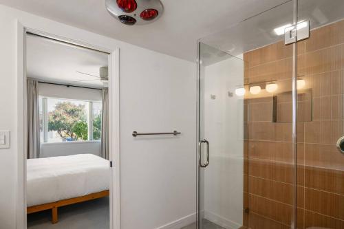 a bathroom with a glass shower and a bed at Joshua Tree Mid Mod - Pool - Spa - Sauna - Fire pit in Yucca Valley