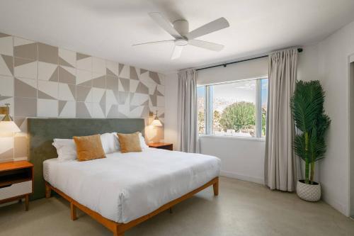 a bedroom with a bed and a window at Joshua Tree Mid Mod - Pool - Spa - Sauna - Fire pit in Yucca Valley