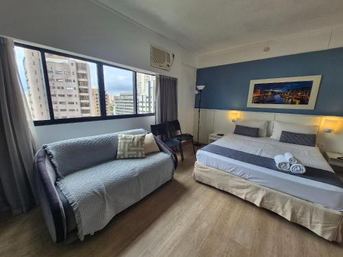 a hotel room with a bed and a couch at Flat Vila Mariana Ibirapuera (Apto 1005) in São Paulo