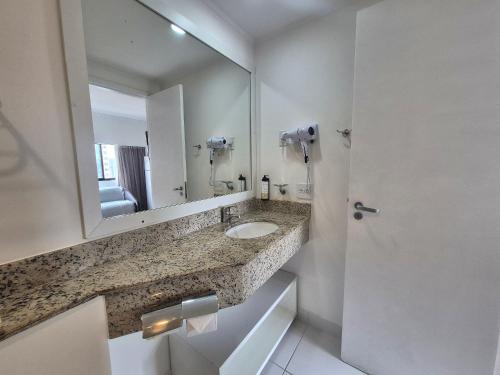 a bathroom with a sink and a large mirror at Flat Vila Mariana Ibirapuera (Apto 1005) in São Paulo