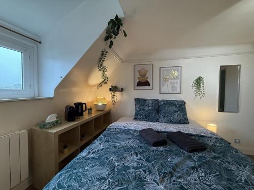 a bedroom with a bed with a blue comforter at Le Studio Dunois in Châteaudun