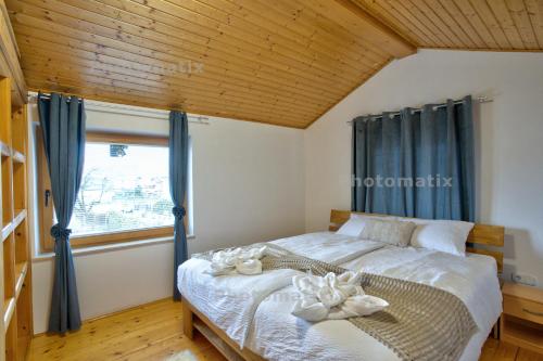 a bedroom with a bed with blue curtains and a window at Rustica Apartments in Maribor