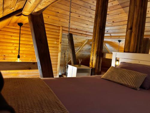 a bedroom with a bed in a wooden cabin at Lozanski ambar in Boljevac