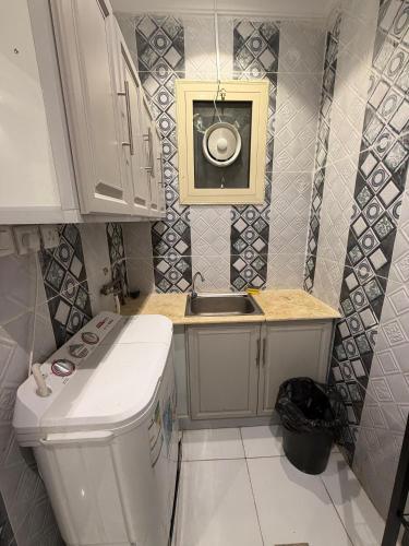 a small kitchen with a sink and a toilet at النبلاء الفضي in Medina