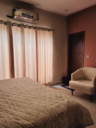 a bedroom with a bed and a chair at Livora stays Cozy Luxury 1BHK in Multan