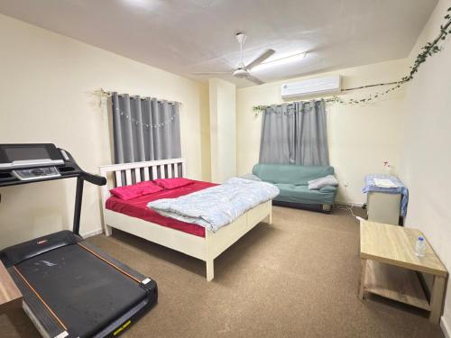 a room with a bed and a treadmill in it at Qidfa apartment in Qidfi‘