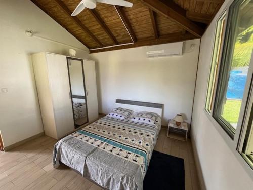 a bedroom with a bed and a large window at Coin tranquille in Sainte-Anne