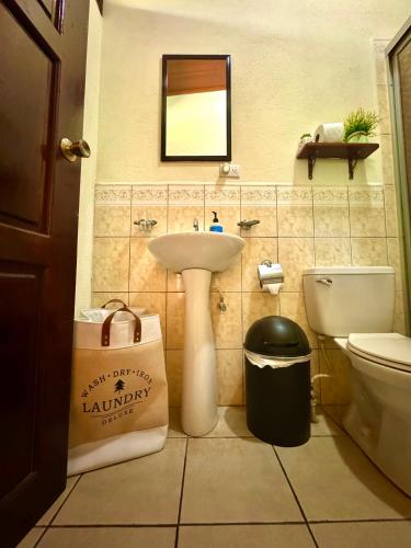 a bathroom with a sink and a toilet and a mirror at Casa Lula León Hostal in León