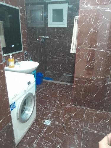 a bathroom with a washing machine and a sink at Apartment Cela Vlore in Vlorë