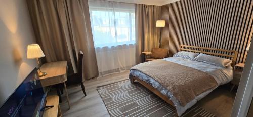a bedroom with a bed and a desk and a television at Twickenham and West Middlesex Rooms Isleworth Stay in Isleworth
