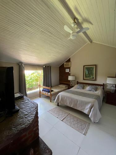 a bedroom with a bed and a ceiling fan at Pousada das Estrelas in Areal