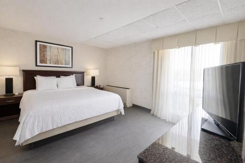 a bedroom with a bed and a flat screen tv at Hotel Lotus Kansas City Stadium in Kansas City