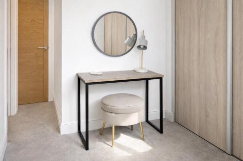 a dressing table with a stool and a mirror at Margate Penthouse Private Balconies Sea Glimpses Gated Parking Air-Con The Penthouse Margate in Margate