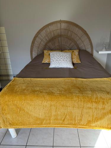 a bed with a brown blanket and pillows on it at Gîtes Ruraux à La Ferme D'Antan in Crolles