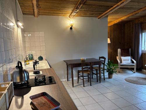 a kitchen with a table and a dining room at Gîtes Ruraux à La Ferme D'Antan in Crolles
