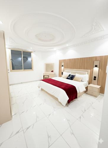 a bedroom with a large bed with a red blanket at النبلاء الفضي in Medina