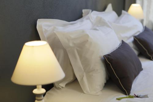 a bed with pillows and a table with a lamp at Residenza Dell' Opera in Turin