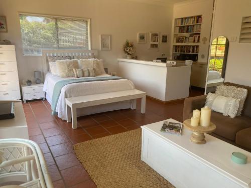 a bedroom with a bed and a living room at Ciara's Cottage CC'S in Illawong