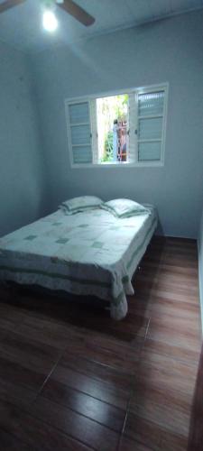a bedroom with a bed in a room with a window at Excelente rancho para descansar e pescar em carlopolis in Carlópolis