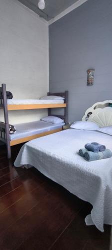 two beds are in a room withthritisthritisthritisthritisthritisthritisthritisthritisthritis at Hospedagem Maranata in Santo André